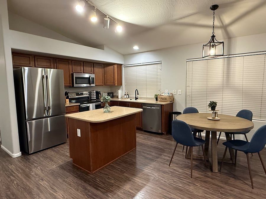 Kitchen with island, stainless refrigerator and dining table in the Maricopa furnished rental