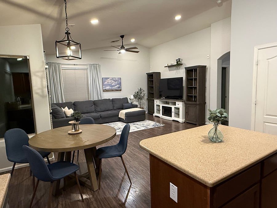Open living room and dining area with vaulted ceiling in the furnished 3-bedroom rental home in Maricopa, AZ